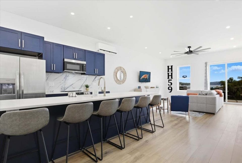 Cook and entertain in this sleek, modern kitchen with navy cabinetry, stainless steel appliances, and a spacious island perfect for gatherings.