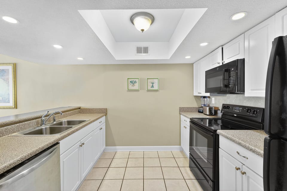 Kitchen - Kitchen with full appliances, including a dishwasher, along with cookware and counter space for preparing meals.