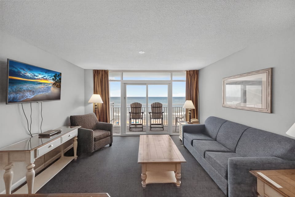 Living Room - Relax in the bright living area with plenty of seating and three flat-screen TVs — ideal for quality downtime with family or friends.