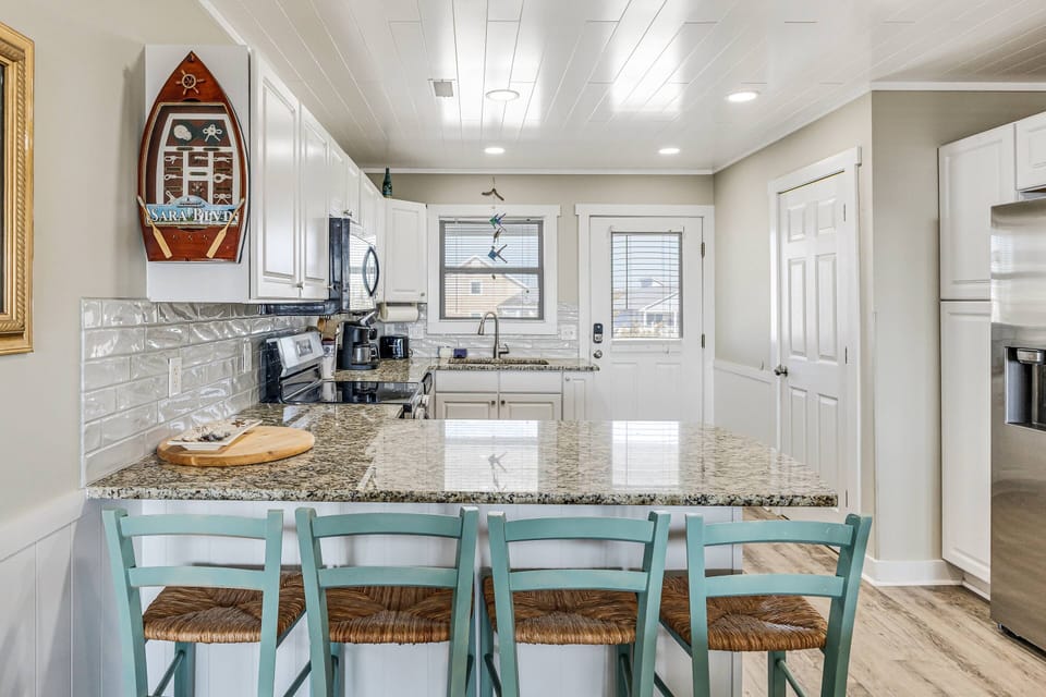 Kitchen with white cabinetry, complete kitchen appliances, and ample natural light.