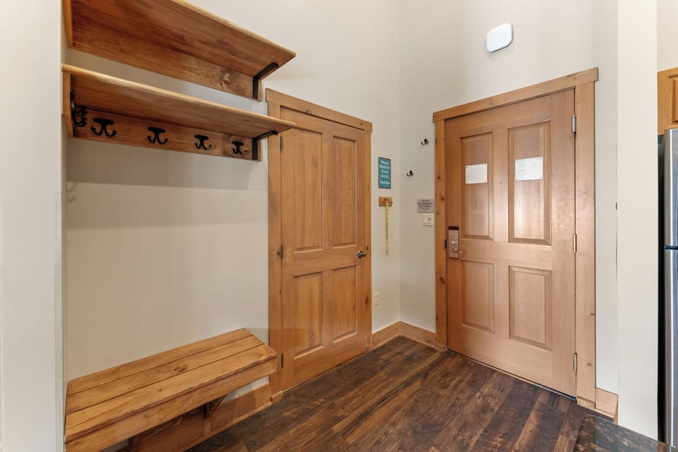 Your private entryway welcomes you with warm wood accents, built-in storage bench, and hooks for your coats and gear.
