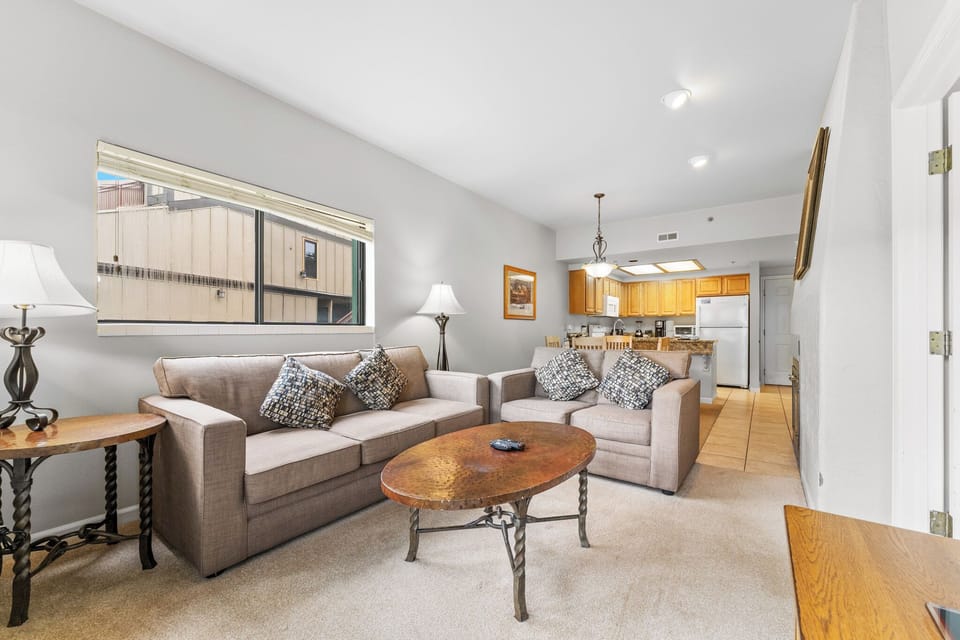 Relax in your spacious living room with plush seating and natural light, flowing seamlessly into a fully equipped kitchen for home-cooked comfort.