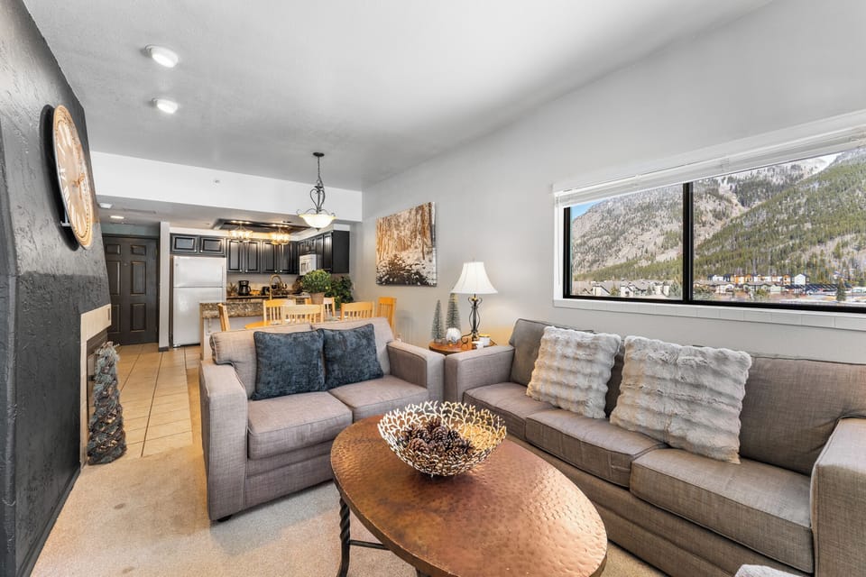 Unwind in your spacious living room where plush sofas and mountain views create the perfect backdrop for memorable evenings together.