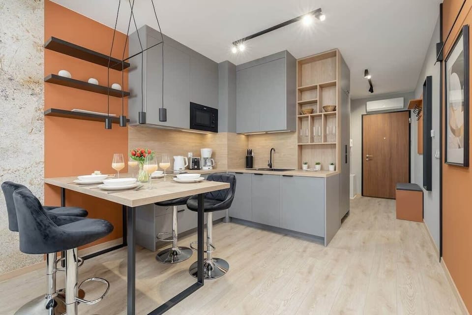 Compact kitchen with modern cabinets, bar stools, and wooden accents.
