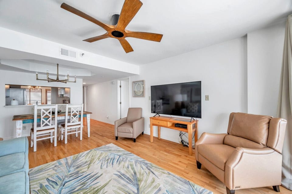 Relaxed living space w/ cozy seating, TV & warm wood floors.