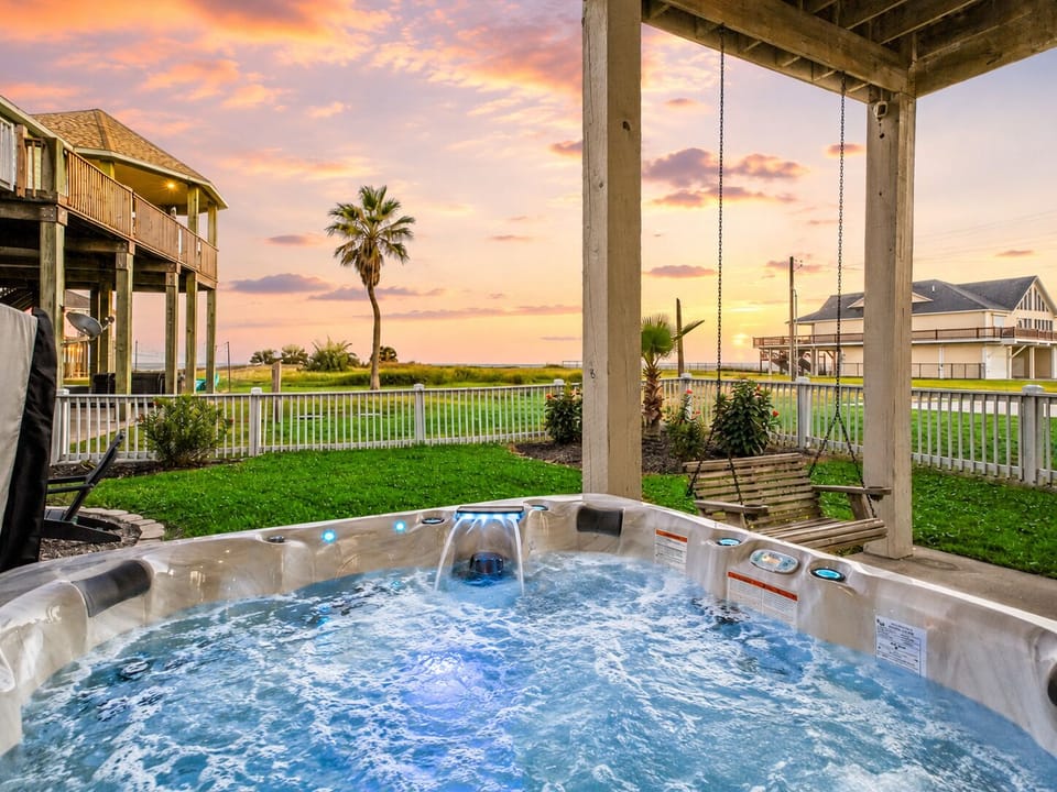 Covered private hot tub area with Gulf views, fenced yard, and relaxing outdoor space for soaking after a beach day in Galveston.