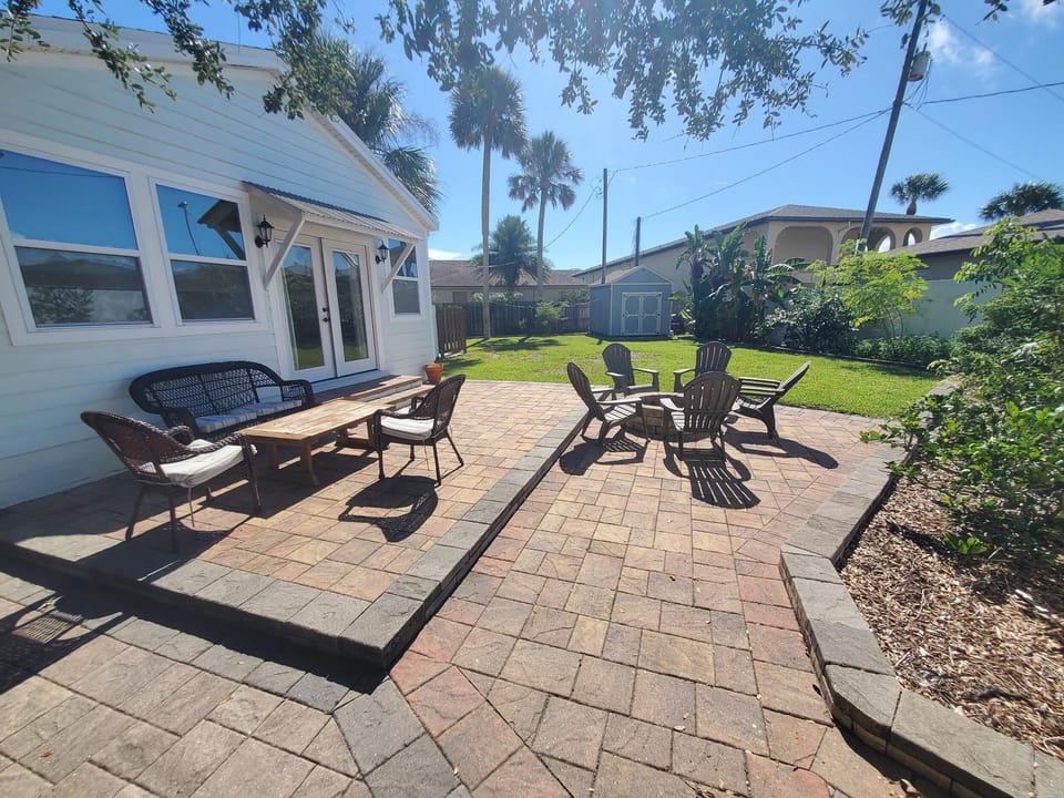 Sunny backyard patio with comfortable seating and lush surroundings.