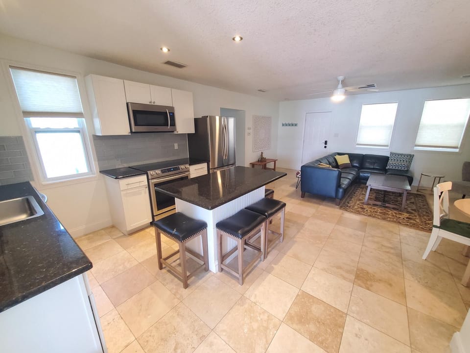 Modern open-plan kitchen and living area with breakfast bar and comfortable seating.