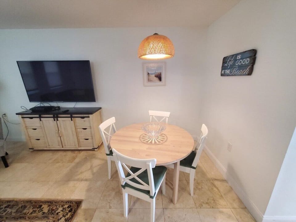 Cozy dining area with a round table and TV, ideal for relaxed meals.