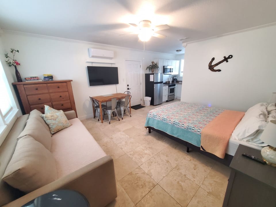 Bright studio with a king bed, kitchenette, and cozy sitting area.