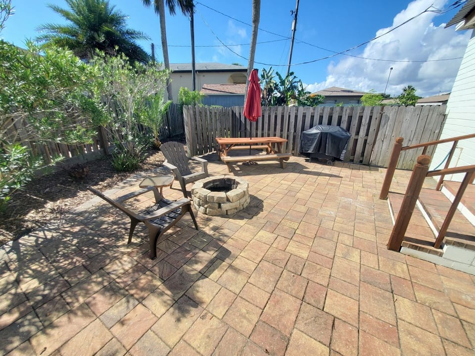 Private backyard with firepit, seating area, and BBQ grill.