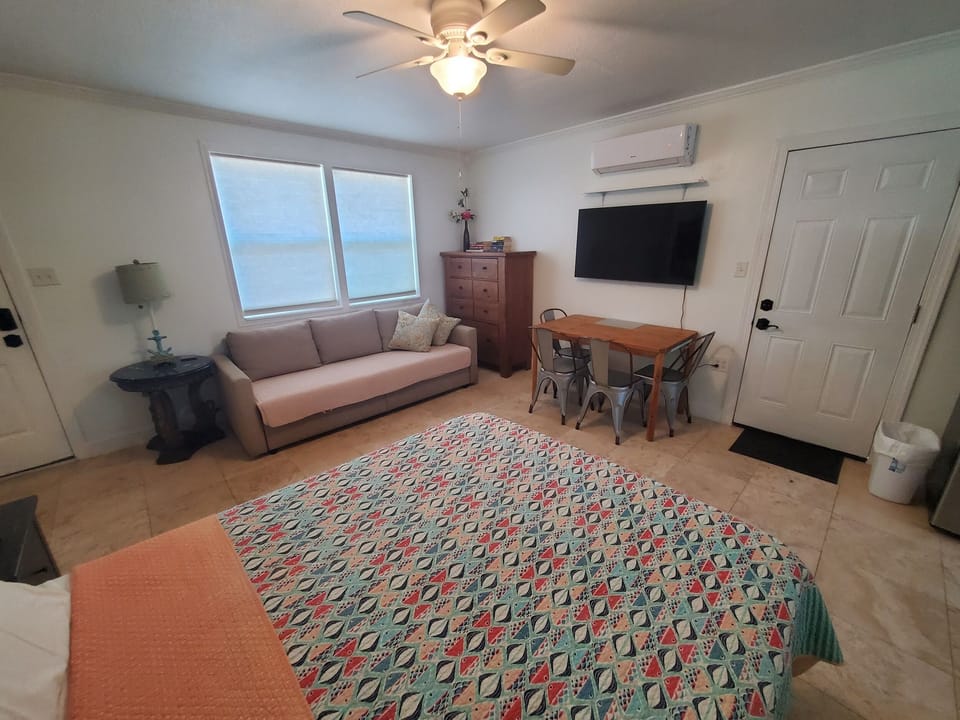 Cozy lakefront studio with comfortable seating, dining area, and scenic views.
