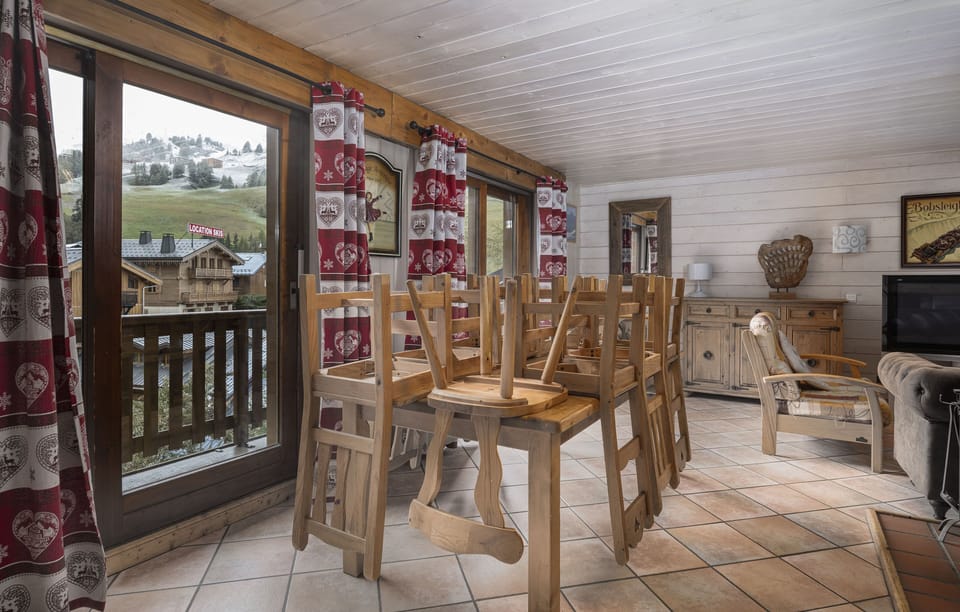 Spacious dining area with direct access to a balcony, perfect for enjoying meals with mountain views.