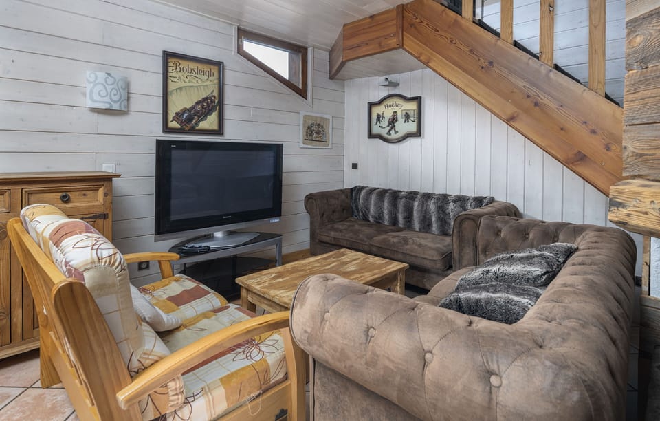 Cozy living room with plush seating and a TV, ideal for relaxing after a day on the pistes.