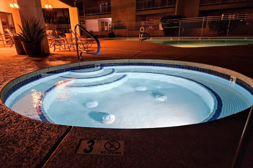 Oversized salt water spa/ hot tub in a gated pool area. 