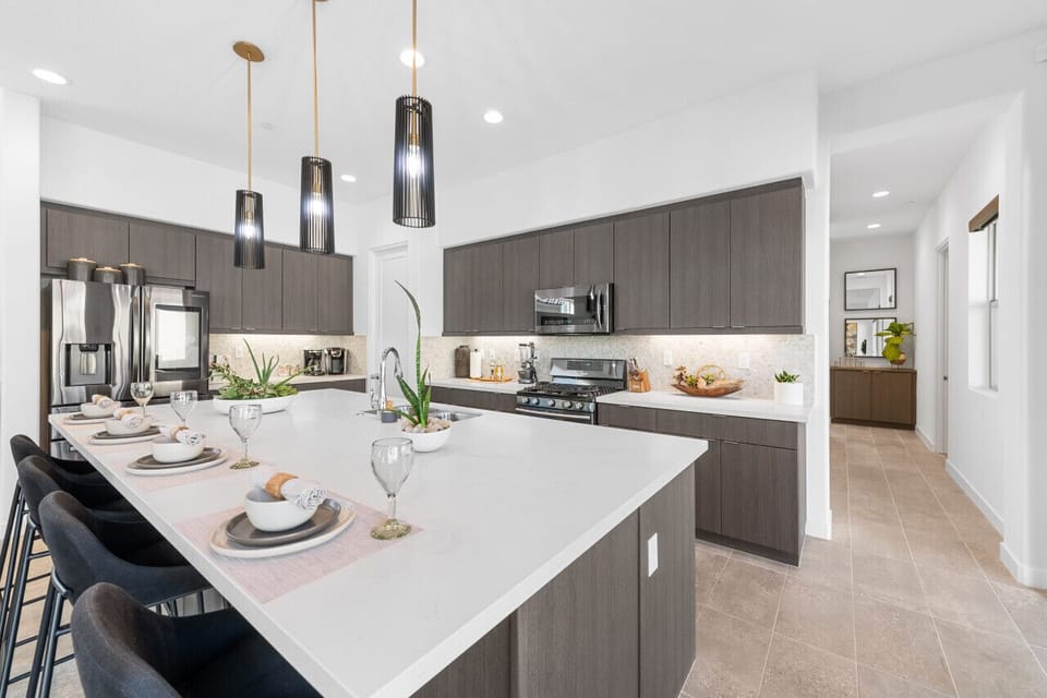 Modern kitchen w/ large island, pendant lighting & sleek stainless steel appliances
