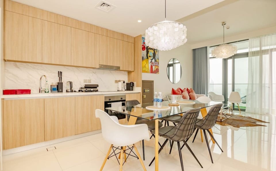 A stylish dining area with modern chairs, adjacent to a fully equipped kitchen with high-end appliances.