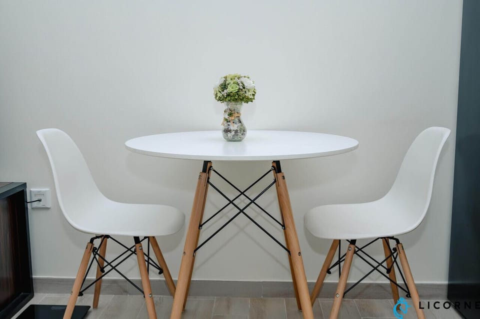 Charming dining table with two comfortable chairs, perfect for enjoying a meal or working remotely.