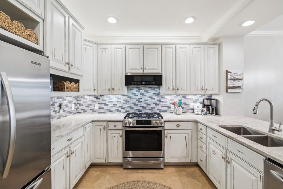 Cook to your heart's content in this bright, fully-equipped kitchen with gleaming appliances and elegant backsplash.