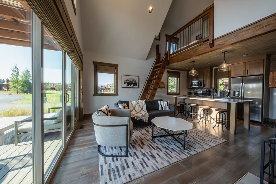 Enjoy the bright living space with queen sofa sleeper, Smart TV, and deck access