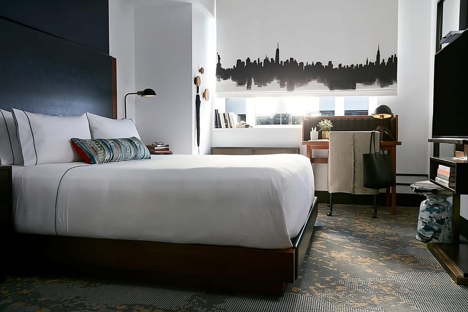 Unwind in crisp linens beside sunlit windows and workspace.