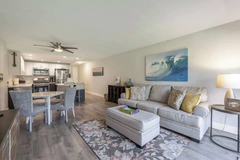 Living area features a queen sofa sleeper, dining table for 4, ottoman, ceiling fan, window AC, and smart TV with cable