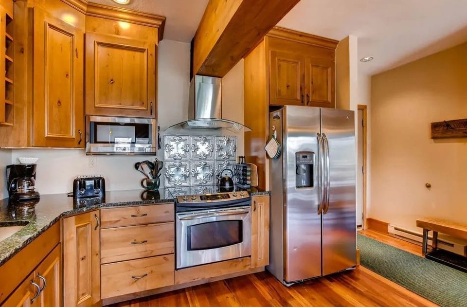 The modern kitchen features sleek stainless steel appliances and rich wooden cabinetry, blending functionality and style for effortless meal preparation.