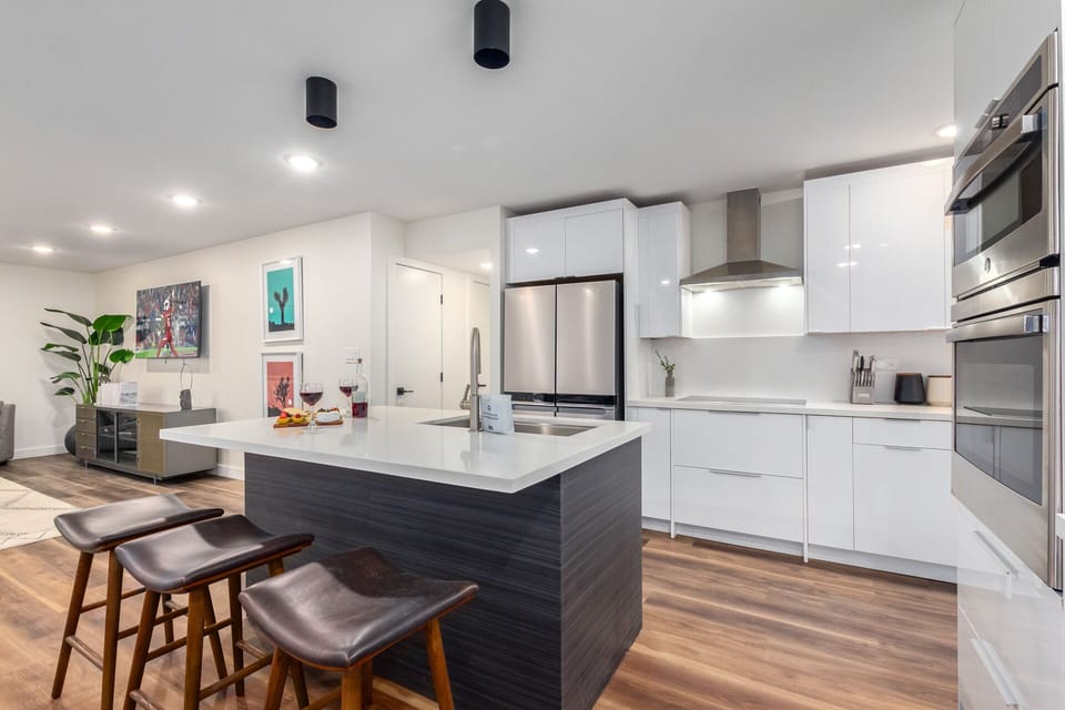 Elaborate kitchen with stainless steel appliances and a kitchen island with bar seating for 3 guests.