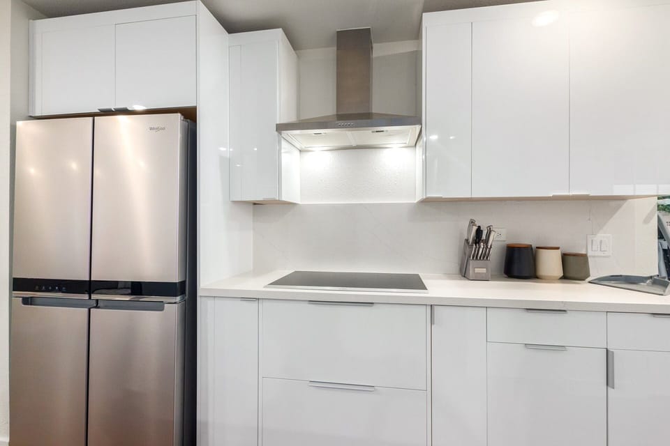 Elaborate kitchen with stainless steel appliances and a kitchen island with bar seating for 3 guests.
