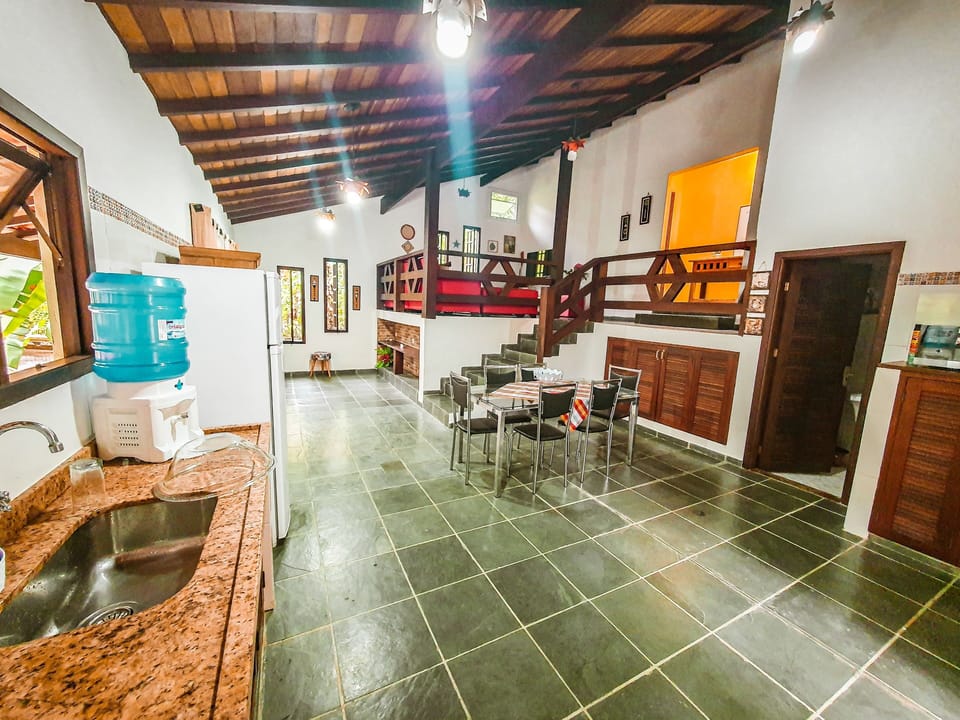 Vista geral da cozinha e escada para a sala de estar e suítes.