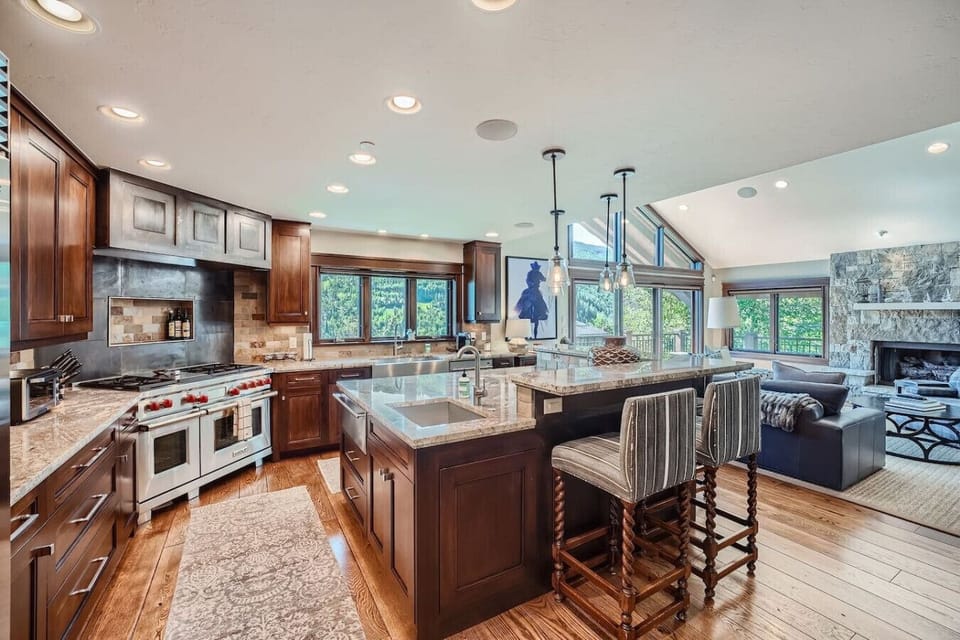 Experience luxury in an open kitchen concept featuring top-of-the-line Wolf gas stove, Sub-Zero fridge, and dual sinks for effortless meal prep. Perfectly designed for culinary enthusiasts and entertaining in style!