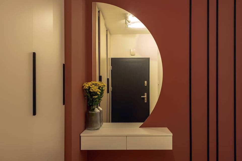 A decorative wall with a mirror and linear lighting adds character and style even to a compact space.