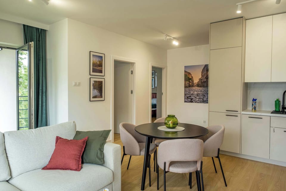 The living room with a light sofa and round table invites shared moments in a comfortable and welcoming setting.
