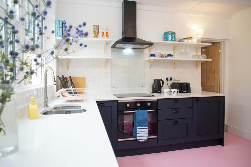 Kitchen with marble effect work surface. Electric cooker and extractor hood