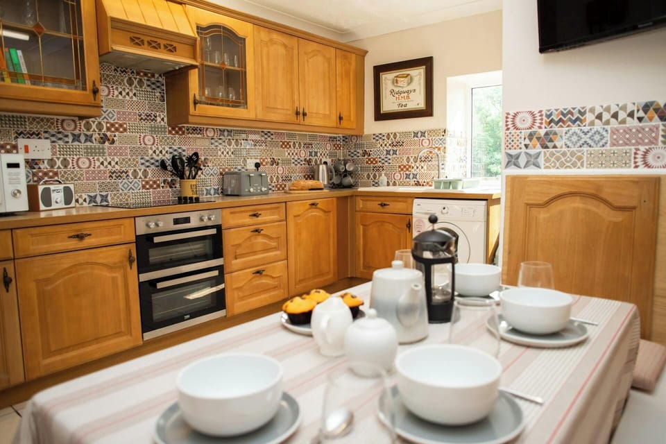 Kitchen with table and chairs. Multi patterned tiles and wall and base cupboards