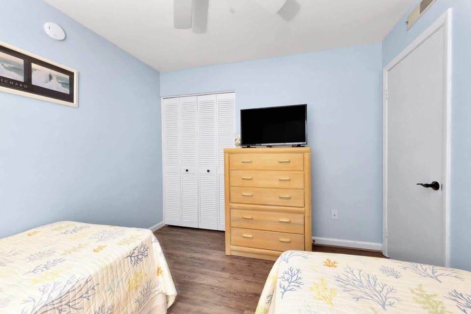The second bedroom includes a pair of cozy twin beds & Smart TV