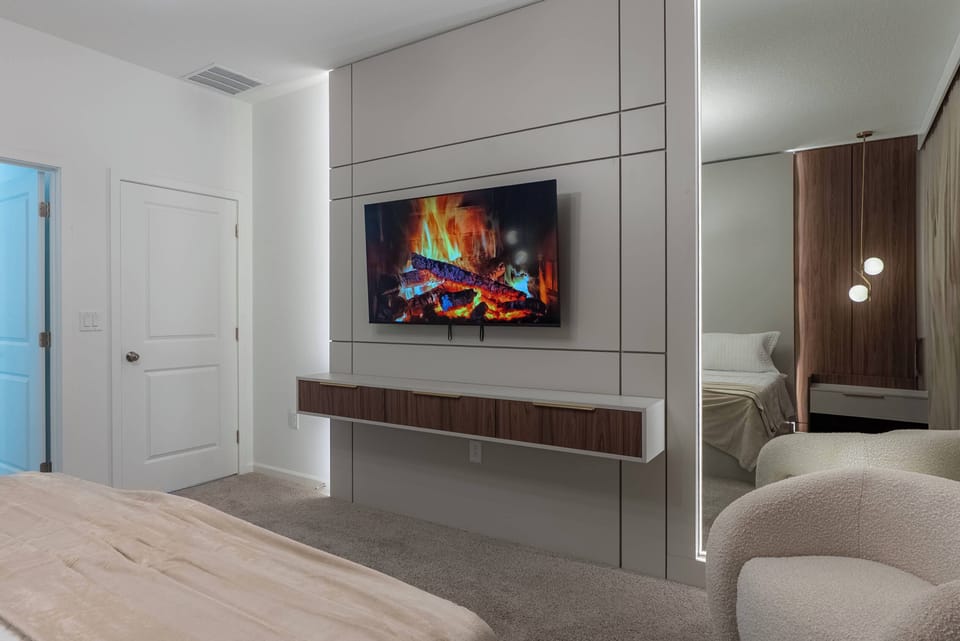 Unwind in this beautifully designed bedroom with a comfy bed and a modern wall-mounted TV. The soft beige tones and warm lighting create a welcoming atmosphere, ideal for relaxing after a day of adventure.