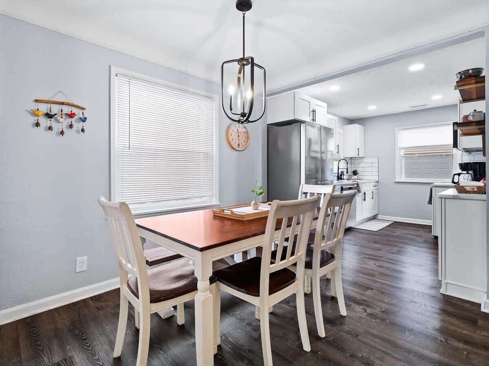 Dining area w/ table set for meals, flowing seamlessly into the kitchen