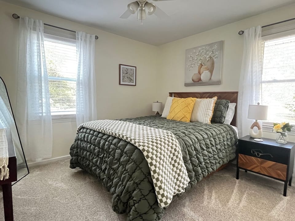 Queen bedroom with green accents and abundant natural light.