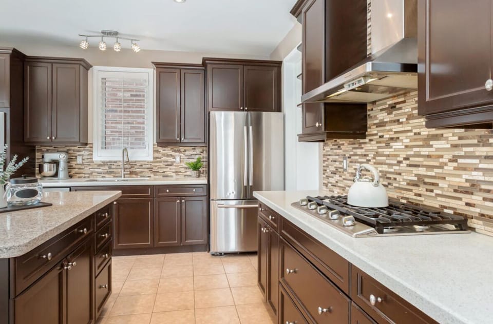 Bright kitchen with stainless steel appliances, island, dining area & coffee bar