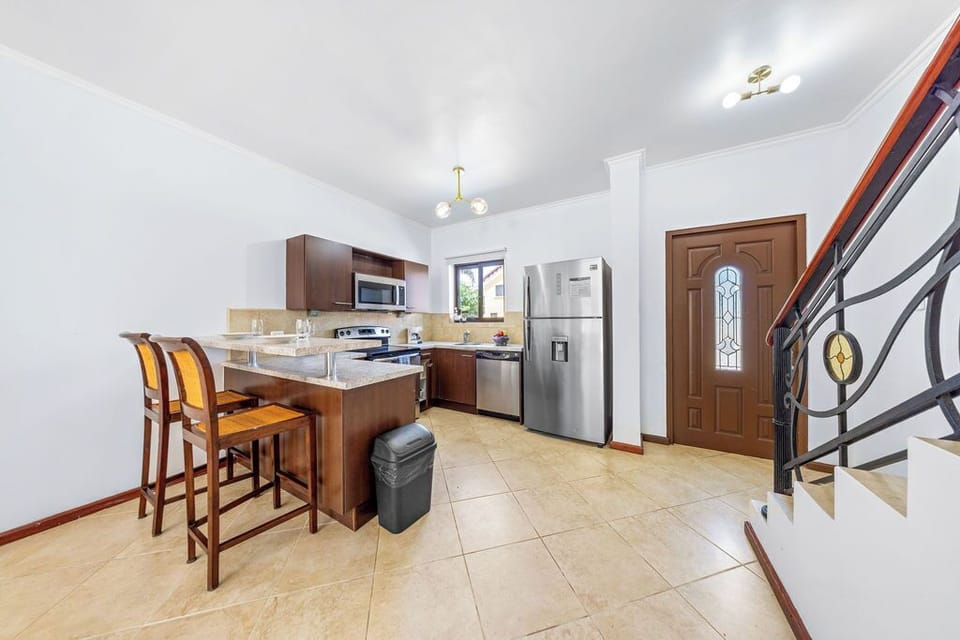 Fully equipped kitchen with stainless steel appliances, including a full refrigerator, dishwasher, and stove, ready for all your culinary adventures.