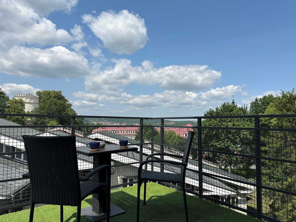 A balcony with greenery view and spacious garden furniture invites you to enjoy morning coffee.