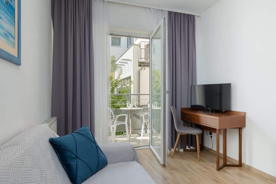 Living room with an access to balcony and remote working space.