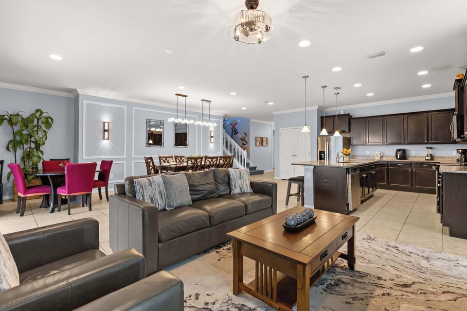 Open-Concept Lounge: Relax in the stylish main lounge featuring plush sofas, a large smart TV, and a stunning feature wall with modern lighting — perfect for movie nights or family hangouts.
