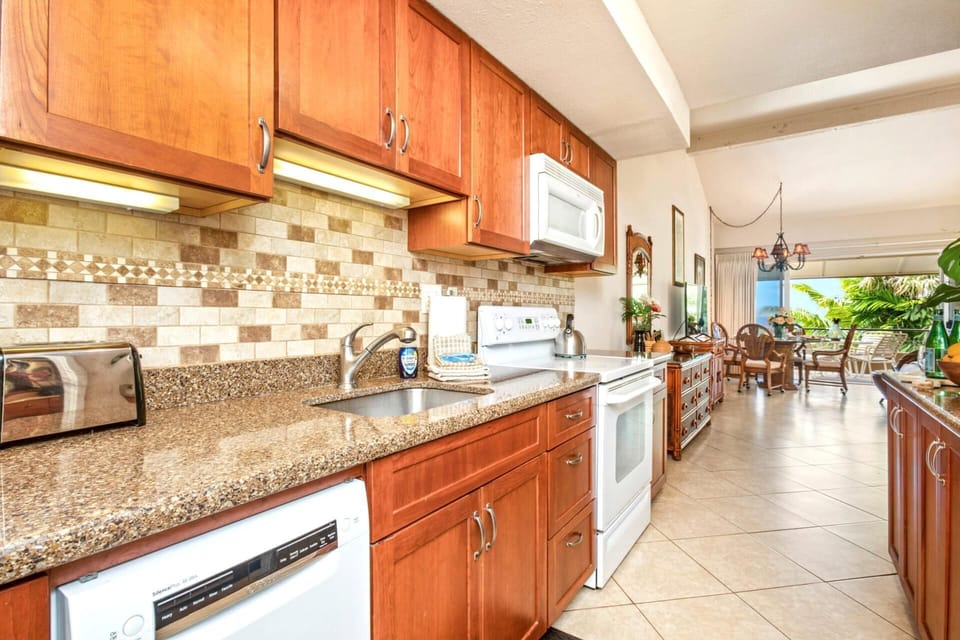 Where polished granite meets tile cheer, this kitchen invites you to stir up snacks, sunshine, and seaside stories    