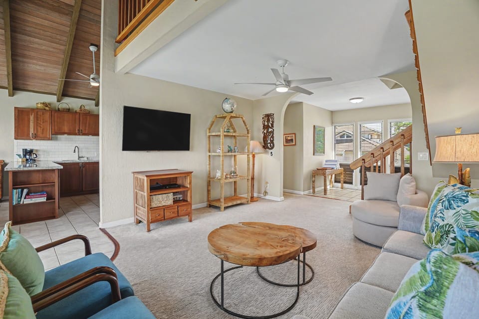 Settle into your bright, open living space with vaulted ceilings, tropical accents, and plenty of room to unwind. Natural light fills every corner, inviting you to relax in style.