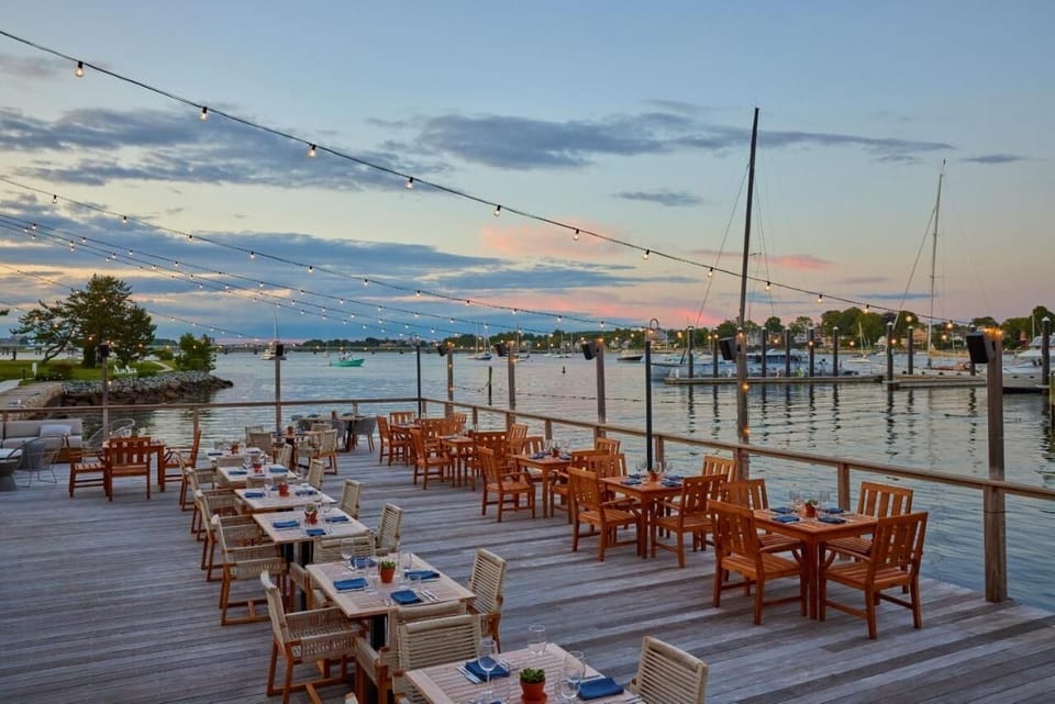 Unwind at sunset under twinkling lights beside the marina.
