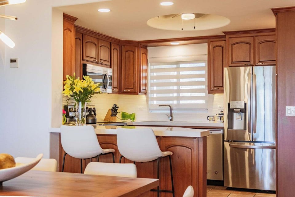 Modern kitchen with stainless appliances and additional seating at the bar
