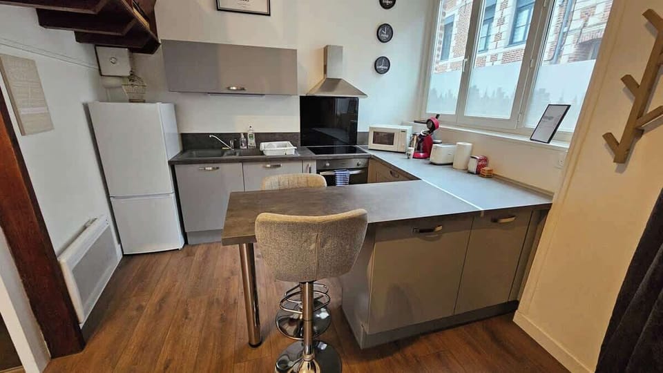 Cuisine équipée avec frigo, machine à café, four, plaques de cuisson, micro-ondes, bouilloire.
Coin repas pour deux personnes grâce aux deux tabourets.
