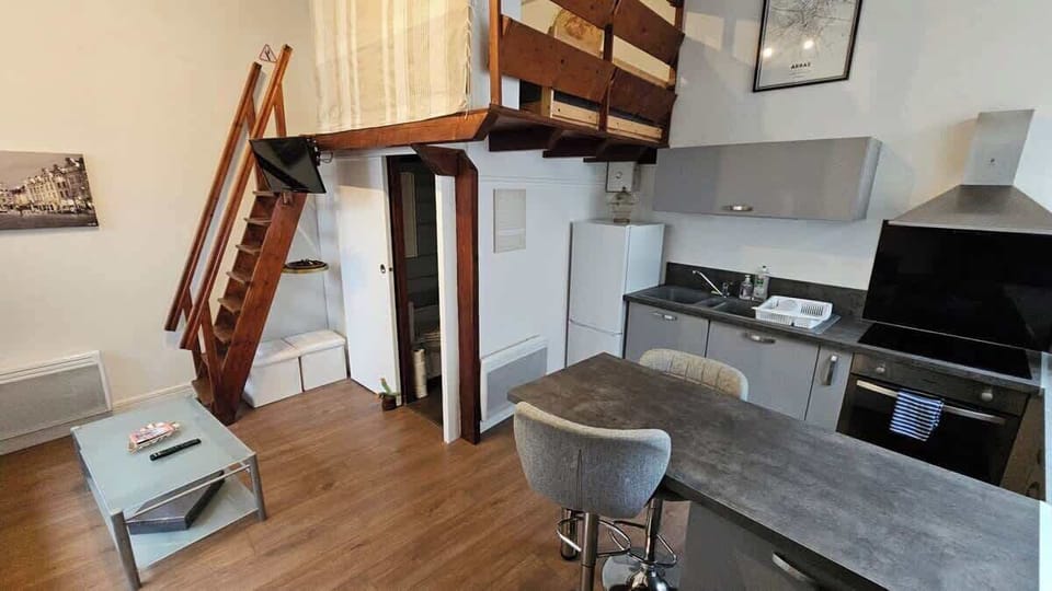 Cuisine ouverte sur le salon, elle est toute équipée avec frigo, four, plaques de cuisson, machine à café, bouilloire. 
Un coin repas pour deux personnes est aménagé grâce aux deux tabourets au bout du plan de travail.